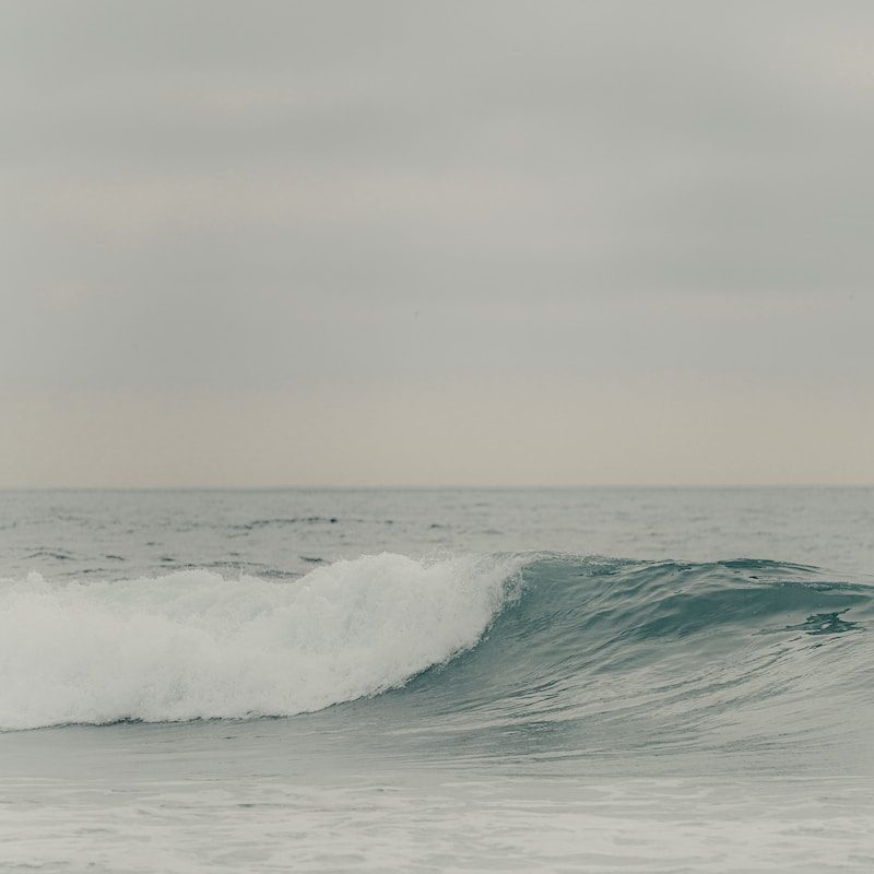 a man riding a wave on top of a surfboard